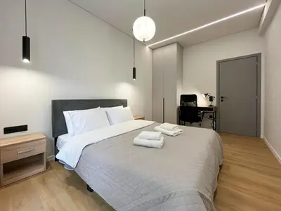 a bedroom with a large bed with towels on it at 3BR Modern & Spacious apt in Athens