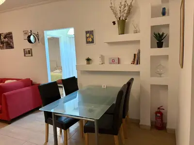 a dining room with a glass table and black chairs at Cozy lower ground floor apartment by Sea and Tram in Athens