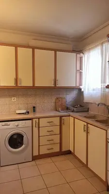 a kitchen with a washer and a washing machine at Cozy lower ground floor apartment by Sea and Tram in Athens
