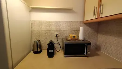 a microwave sitting on top of a kitchen counter at Cozy lower ground floor apartment by Sea and Tram in Athens