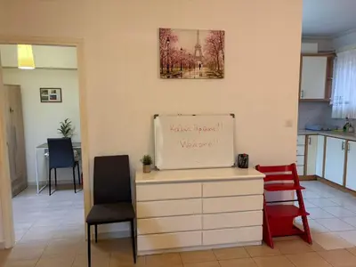 a kitchen with two chairs and a sign on the wall at Cozy lower ground floor apartment by Sea and Tram in Athens