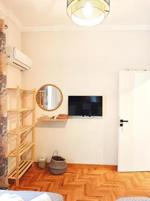 a room with a tv and a mirror on the wall at Central apartment in Athens in Athens