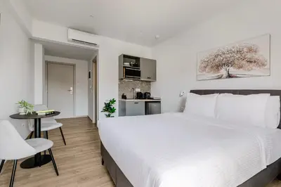 a bedroom with a large white bed and a table at B48 Athens Dafni in Athens
