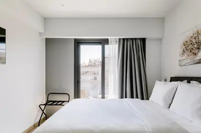 a bedroom with a white bed and a window at B48 Athens Dafni in Athens