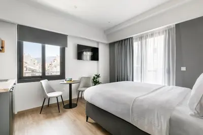 a hotel room with a bed and a table and chairs at B48 Athens Dafni in Athens