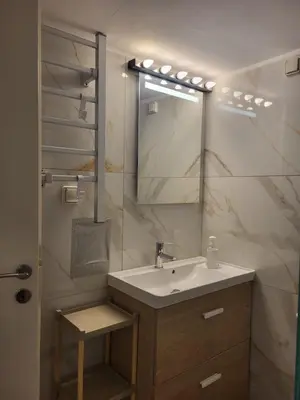 a bathroom with a sink and a mirror at Green apartment-center of Varkiza resort in Vari