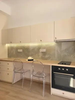 a kitchen with a counter with two chairs and a stove at Green apartment-center of Varkiza resort in Vari