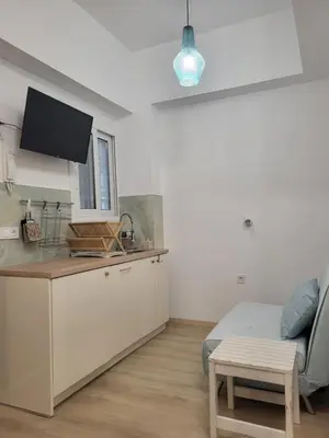 a room with a kitchen and a bed and a table at Green apartment-center of Varkiza resort in Vari