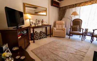 a living room with a television and a chair at 15' to Sea & Acropolis in Athens