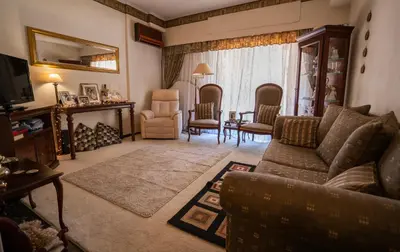 a living room with a couch and chairs and a television at 15' to Sea & Acropolis in Athens