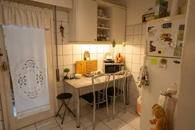 a small kitchen with a table and a refrigerator at 15' to Sea & Acropolis in Athens