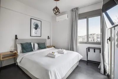 a bedroom with a large white bed and a window at Andromeda - 1 Bedroom Apt & Terrace in Athens in Athens