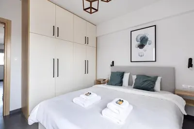 two beds in a bedroom with white cabinets at Andromeda - 1 Bedroom Apt & Terrace in Athens in Athens