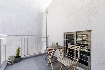 a balcony with a table and chairs on a white wall at Andromeda - 1 Bedroom Apt & Terrace in Athens in Athens