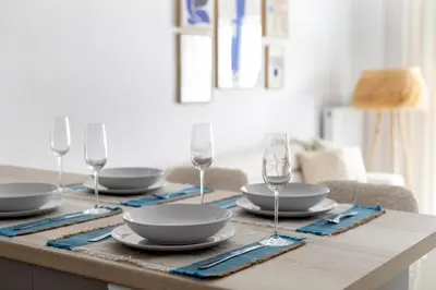 a table with plates and wine glasses on it at Les Nuances de Bleu - 1-Bedroom & Balcony in Athens in Athens