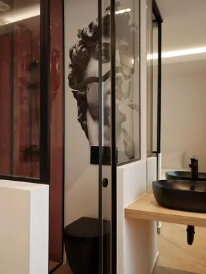 a bathroom with a statue of a head on a wall at Modern Nest Studio in Syntagma in Athens
