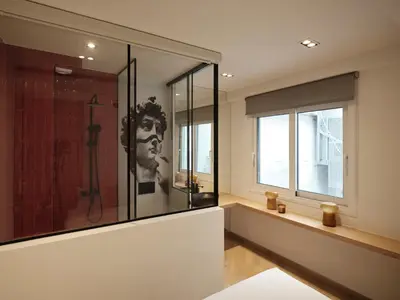 a bathroom with a shower with a painting of a man with a cigarette at Modern Nest Studio in Syntagma in Athens