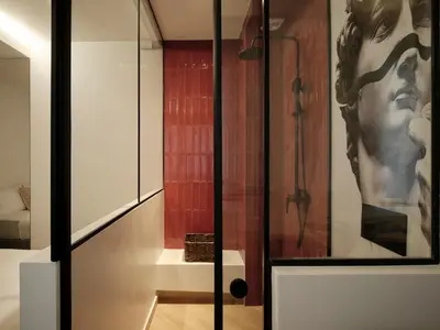 a glass door in a room with a painting of a man at Modern Nest Studio in Syntagma in Athens