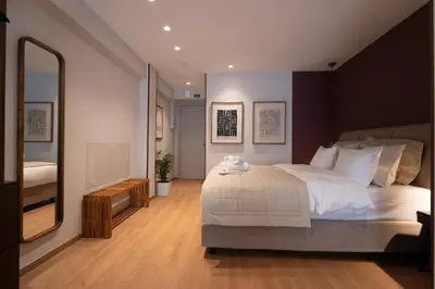 a bedroom with a large bed and a large mirror at Psiri 48 Boutique Suite in Athens