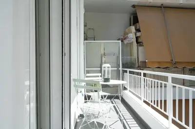 a balcony with a chair and a window at 1BR Next to Metro Modern Living & Arcade Machine in Athens