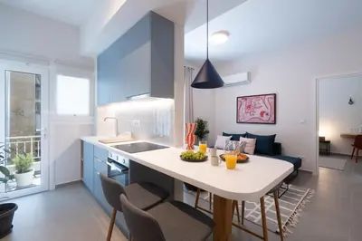a kitchen and living room with a table and chairs at 1BR Next to Metro Modern Living & Arcade Machine in Athens