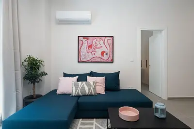 a blue couch in a living room with a table at 1BR Next to Metro Modern Living & Arcade Machine in Athens