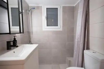 a bathroom with a sink and a toilet and a window at Athens Retreat Paleo Faliro,Onassis,REA Hospital in Athens
