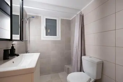 a bathroom with a white toilet and a sink at Athens Retreat Paleo Faliro,Onassis,REA Hospital in Athens
