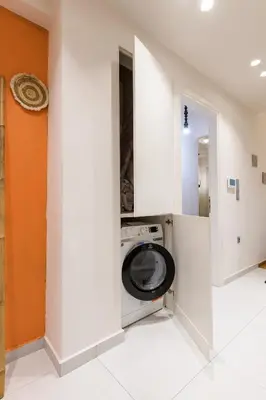 a laundry room with a washing machine in a wall at Nea Smyrni Square Appartment in Athens