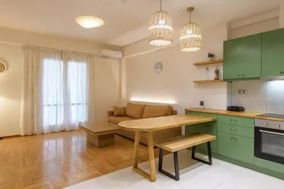 a kitchen and living room with a table and a couch at Nea Smyrni Square Appartment in Athens