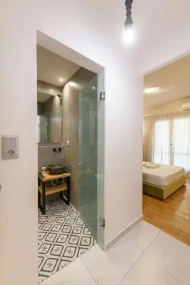 a bathroom with a glass door leading to a bedroom at Nea Smyrni Square Appartment in Athens