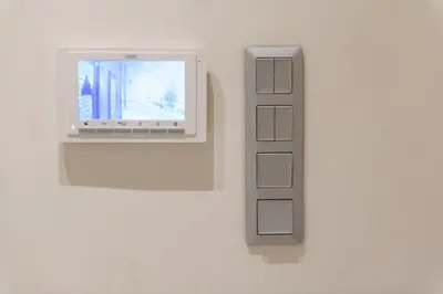 a computer on a wall with a remote control at Nea Smyrni Square Appartment in Athens
