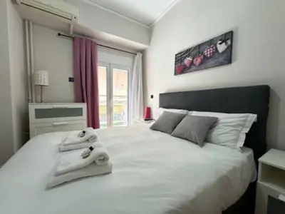 a bedroom with a large white bed with towels on it at Votanikos Urban Nook, Athens in Athens