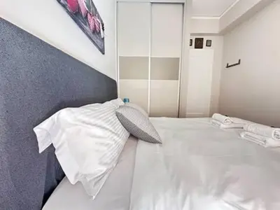 a bedroom with a white bed with a pillow at Votanikos Urban Nook, Athens in Athens