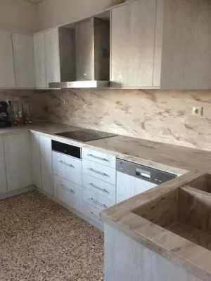 a kitchen with white cabinets and a marble counter top at Villa Agia Marina 5m walk to the beach with private pool in Aghia Marina
