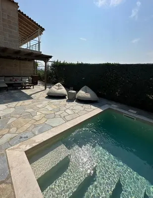 a swimming pool in a yard with a patio at Villa Agia Marina 5m walk to the beach with private pool in Aghia Marina