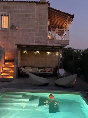 a swimming pool with two boats in front of a house at Villa Agia Marina 5m walk to the beach with private pool in Aghia Marina