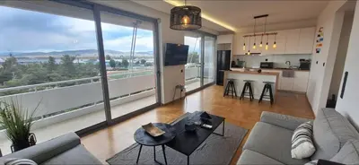 a living room with a couch and a large window at Vip Panoramic view in Athens