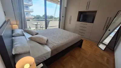 a bedroom with a bed and a tv and a balcony at Vip Panoramic view in Athens