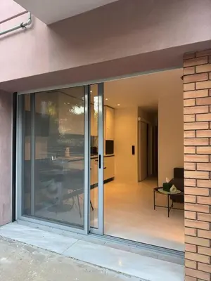 a sliding glass door leading to a living room at Cosy apartment with shared pool and garden in Athens