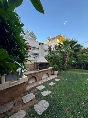 a stone bench in the yard of a house at Cosy apartment with shared pool and garden in Athens