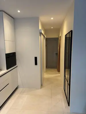 a hallway with white walls and a door to a room at Cosy apartment with shared pool and garden in Athens