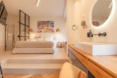 a bedroom with a bed and a sink and a mirror at Koukaki Cityscape in Athens