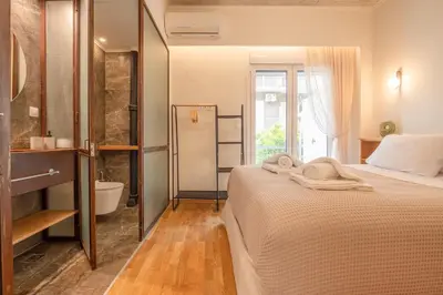 a bedroom with a bed and a bathroom with a tub at Koukaki Cityscape in Athens