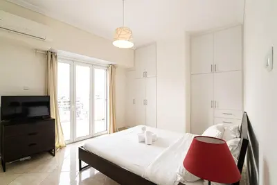 a bedroom with a bed with a red chair and a television at Azotea Con Vista Athens in Athens