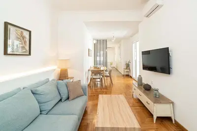 a living room with a blue couch and a tv at Altezza Terrazza Athens in Athens