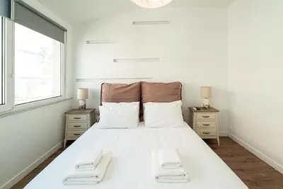a bedroom with a large white bed with two night stands at Altezza Terrazza Athens in Athens