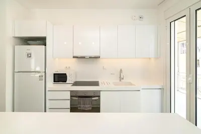 a white kitchen with a sink and a refrigerator at Altezza Terrazza Athens in Athens