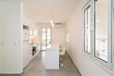 a kitchen with white walls and a large window at Altezza Terrazza Athens in Athens