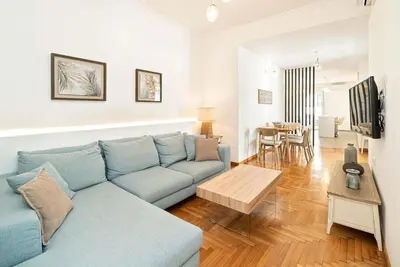 a living room with a blue couch and a table at Altezza Terrazza Athens in Athens